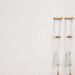 Minimalist image of a pair of crutches leaning on a white wall, symbolizing mobility aid.