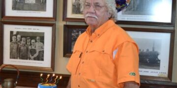 Jimmy French of Hollow Rock standing beside a birthday cake and balloons, remembered as one of the area’s most respected artifact collectors.