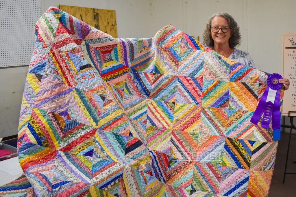 Lois Ford of Bruceton displays her purple ribbon-winning machine pieced, machine quilted entry in the quilts category at the Carroll County Fair.