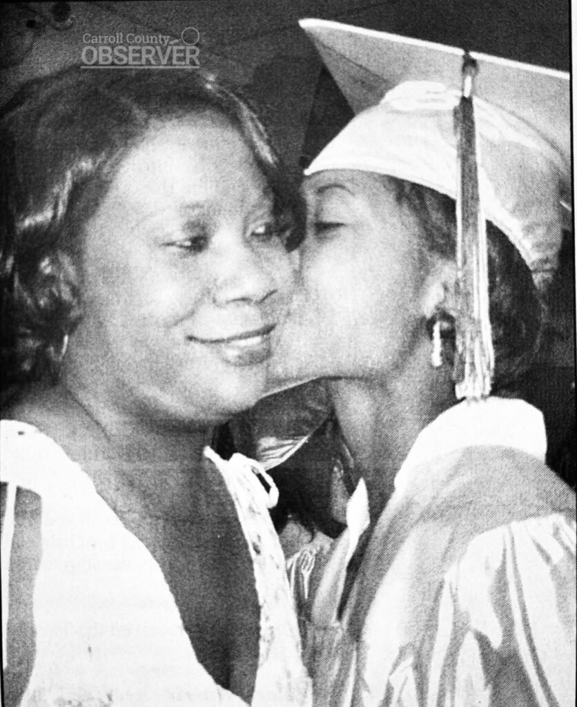 Throwback newspaper photo of Huntingdon High School graduate Lakeshia Sanders (now Dr. Lakeshia Yarbrough) kissing her mother, Lesia Gilbert, on graduation day in 2002. Carroll County News.