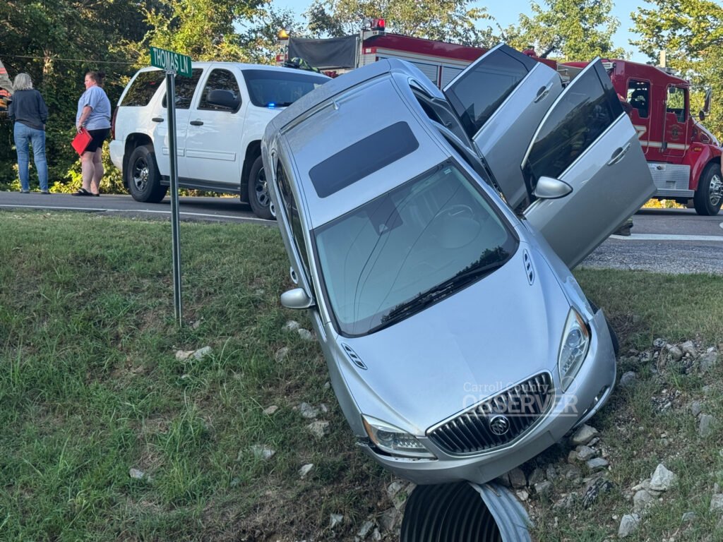 Chains secure a silver Buick as responders work to remove it from a ditch along McLey Highway in Carroll County, Tennessee. Baptist EMS, the Carroll County Rescue Squad, and local firefighters are visible in the background. Photo by Jesse Joseph, Carroll County Observer.