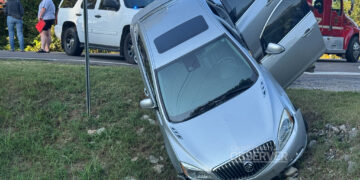 Chains secure a silver Buick as responders work to remove it from a ditch along McLey Highway in Carroll County, Tennessee. Baptist EMS, the Carroll County Rescue Squad, and local firefighters are visible in the background. Photo by Jesse Joseph, Carroll County Observer.