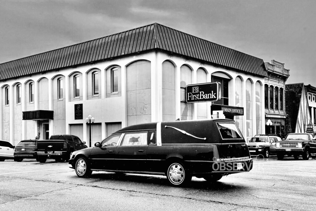 Funeral procession for former Bank of Huntingdon president Ray Smith passing in front of the FirstBank building in Huntingdon, Tennessee, 2024. Photo by Jesse Joseph/ Carroll County Observer