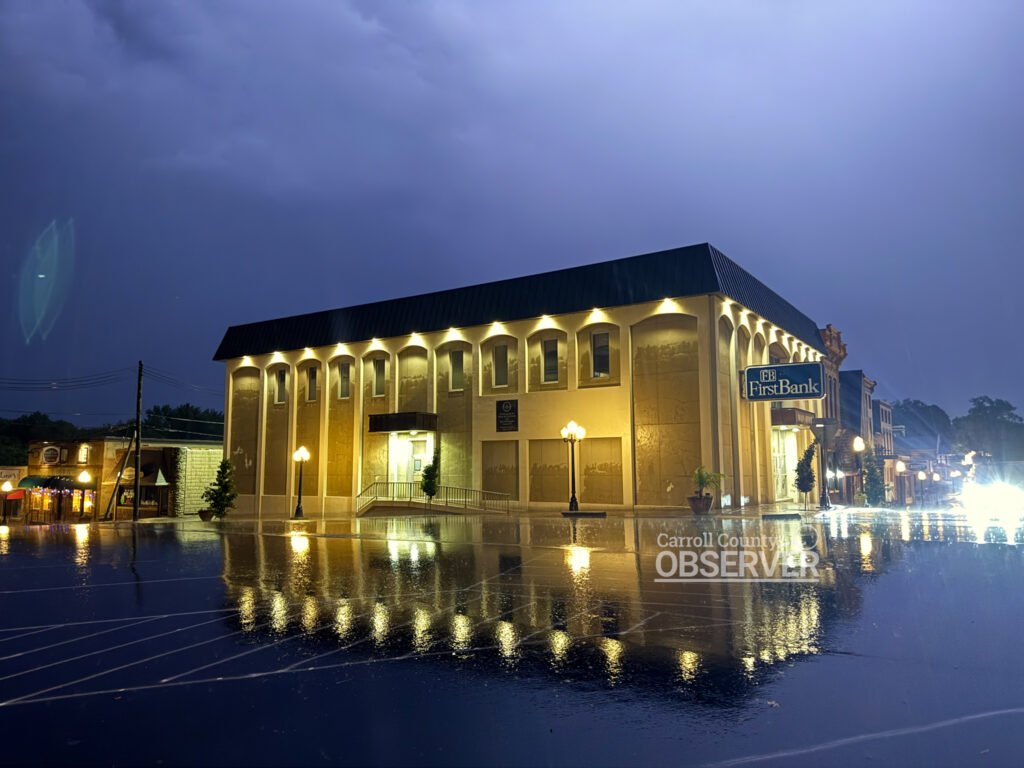 FirstBank building in Huntingdon, Tennessee, lit up during a May 2025 thunderstorm with lightning striking in the night sky. Photo by Jesse Joseph/ Carroll County Observer