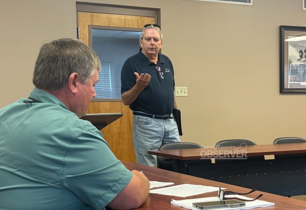 Commissioner Cyril Ostiguy speaks to the Carroll County Finance Ways and Means Committee on August 28, 2025, about his proposed $600 training incentive for commissioners, with Committee Chair Darrell Ridgely in the foreground. Photo by Jesse Joseph/Carroll County Observer
