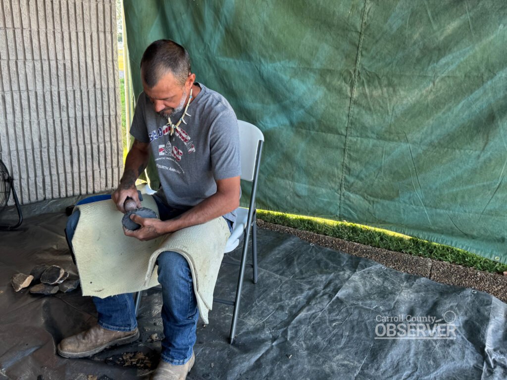 Jeremy Milam demonstrates flint knapping outside the Carroll County Civic Center during the Jimmy French Memorial Artifact Show. Photo by Jesse Joseph/Carroll County Observer.