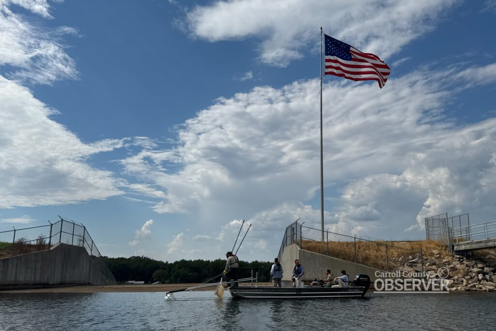 Governor Bill Lee stands aboard a TWRA electrofishing boat beneath an American flag at Lake Halford, participating in a demonstration of fish population monitoring. Photo by Jesse Joseph/Carroll County Observer.