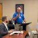 Chief Deputy Joel Pate speaks at a podium while Carroll County Mayor Joseph Butler listens at the Commission meeting. Pate explained that a diagnostic review is the first step toward safety improvements at the Harris Road railroad crossing. Photo by Jesse Joseph/Carroll County Observer.