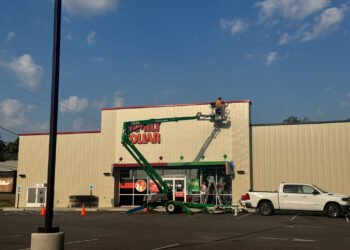 Workers remove Dollar Tree signs from the Family Dollar combo store in Bruceton, Carroll County, Tennessee, on September 17, 2025, after the national retailer’s $1 billion Family Dollar sale and widespread store closures.