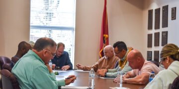 Huntingdon Town Council members seated around a table reviewing documents during a meeting at Huntingdon City Hall.