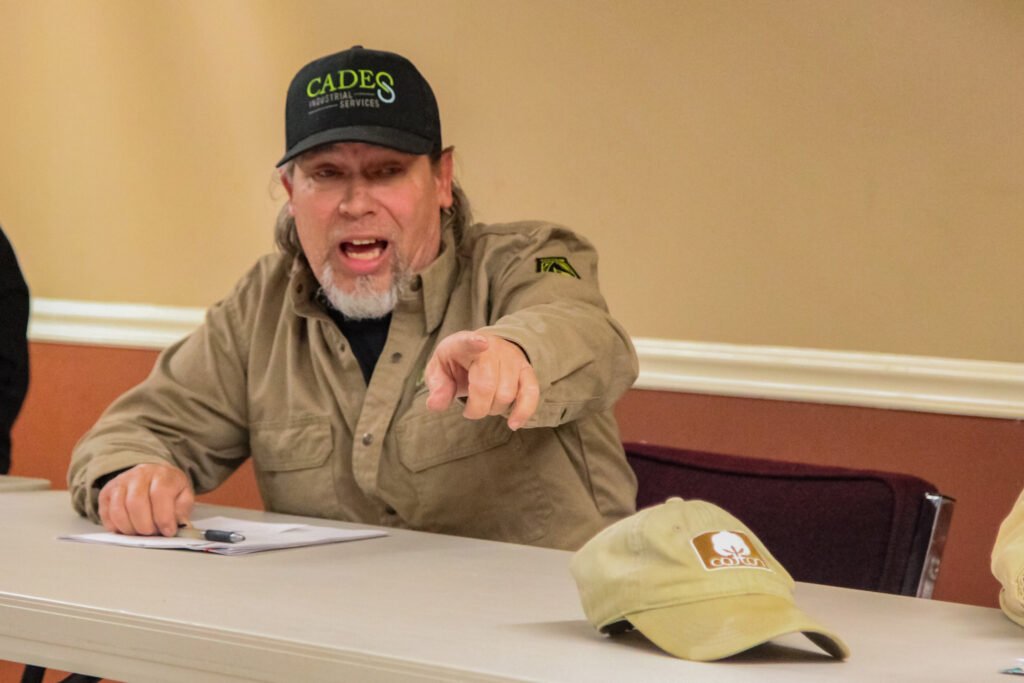 Alderman Tommy Polinski leans forward pointing during a heated exchange at the Atwood town meeting.