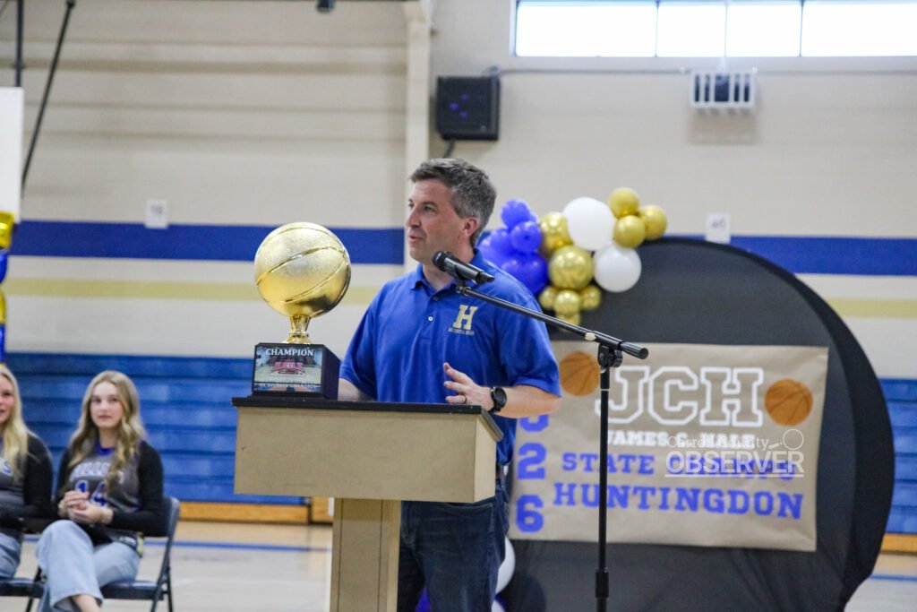 State Rep. Brock Martin speaking at podium with state championship trophy at HMS Fillies celebration.