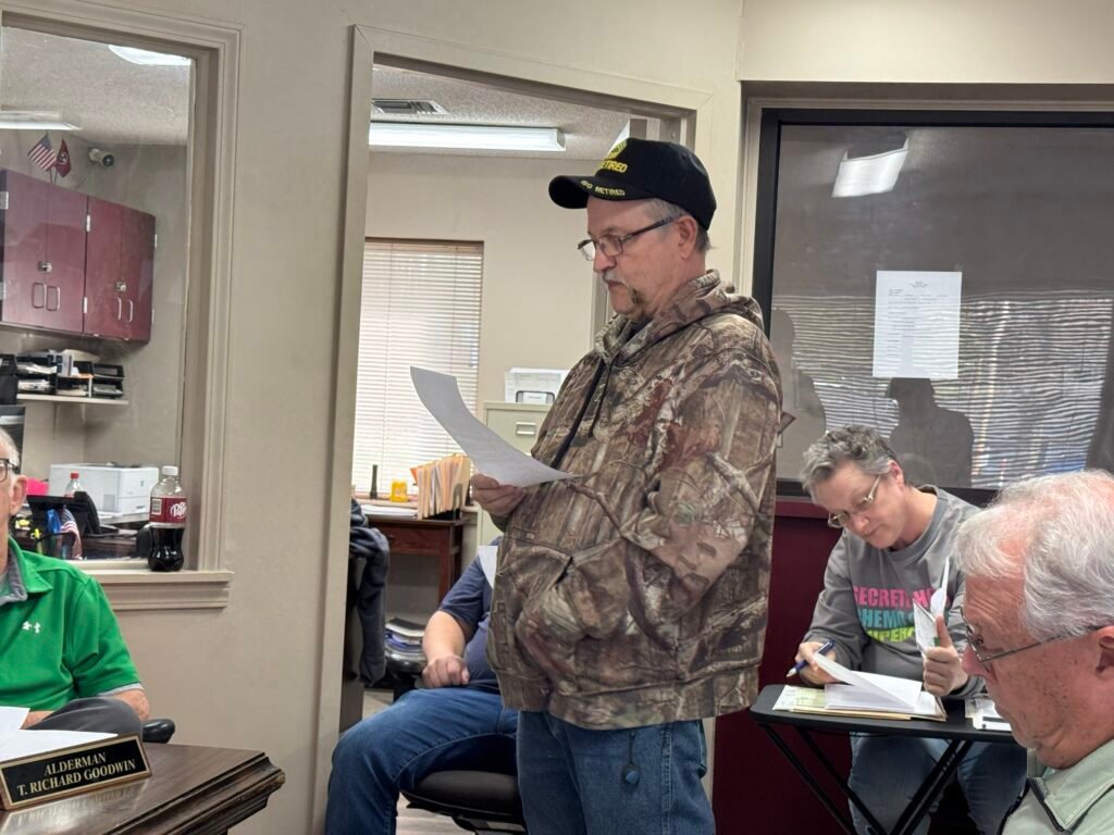 Hollow Rock Police Chief Tim Reeves stands and reads his retirement letter aloud to the board.