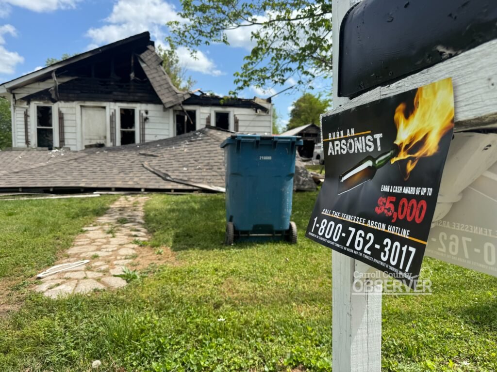 TBI "Burn an Arsonist" flyer on a mailbox with the destroyed home visible in the background.