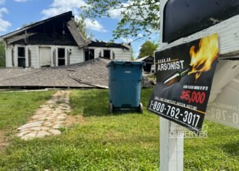 TBI "Burn an Arsonist" flyer on a mailbox with the destroyed home visible in the background.