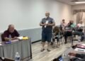Trezevant resident John Quinn standing and addressing the board at April 2026 meeting with Alderman Mark Argo seated at table.