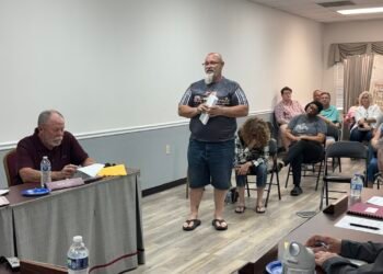Trezevant resident John Quinn standing and addressing the board at April 2026 meeting with Alderman Mark Argo seated at table.