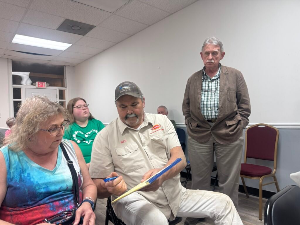 City attorney Charles Trotter standing as prospective IDB members sign availability sheet at Trezevant board meeting.