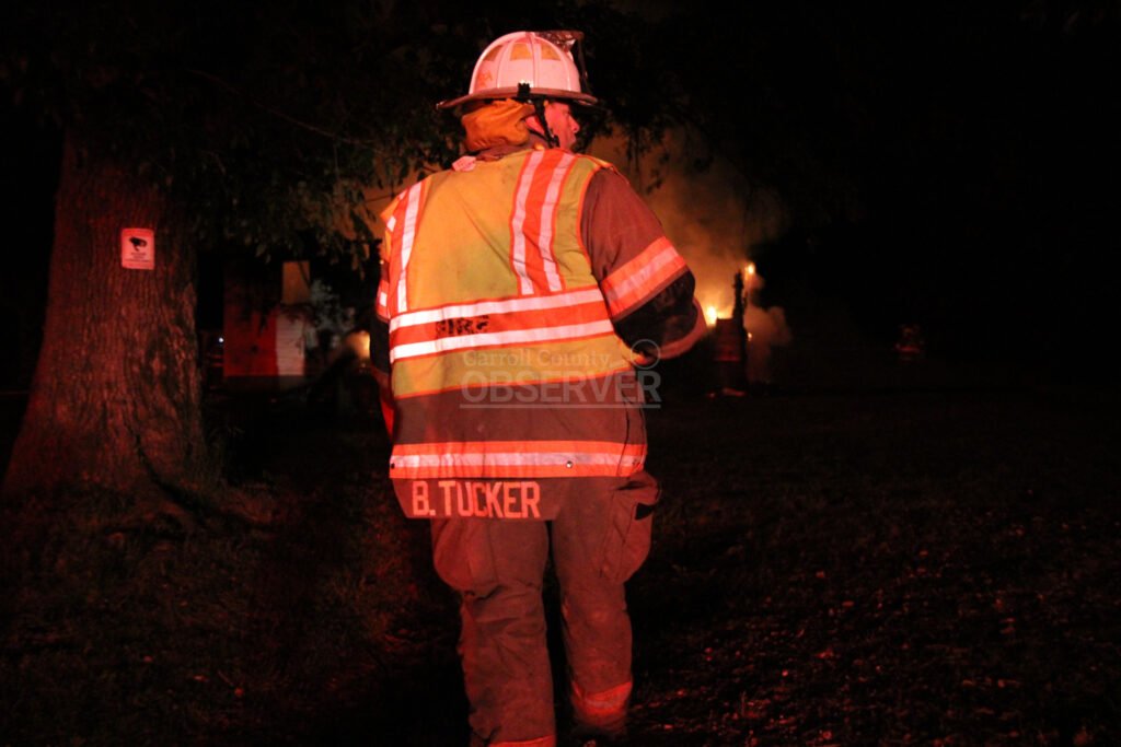 McKenzie Fire Chief Brian Tucker in gear at the scene of a house fire at night.