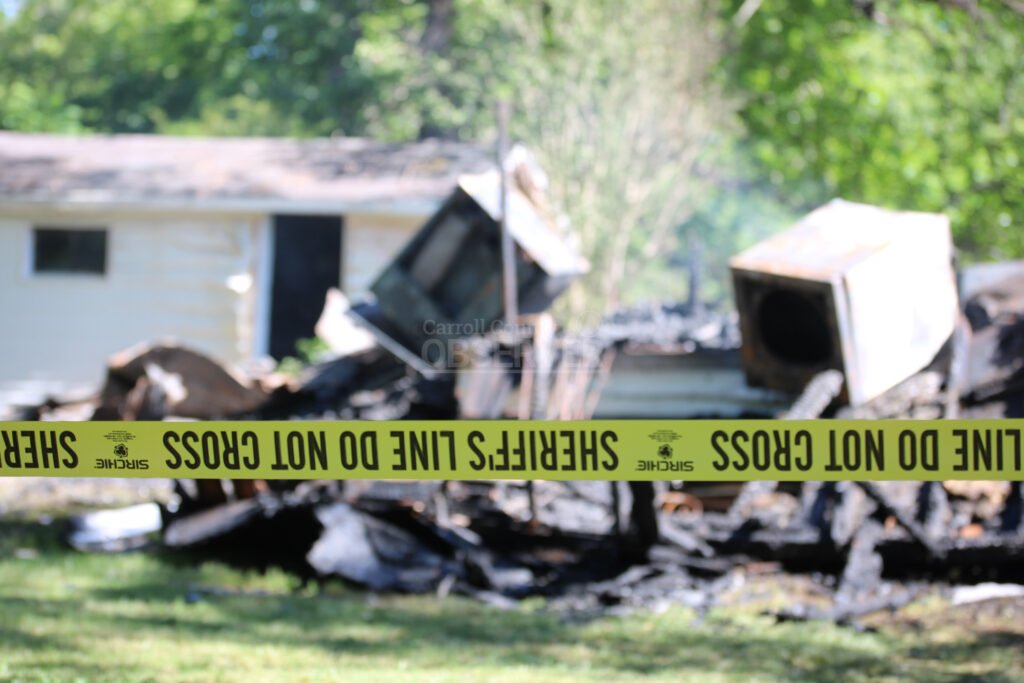 Yellow sheriff's tape surrounds the burned ruins of a house in McKenzie, Tennessee.
