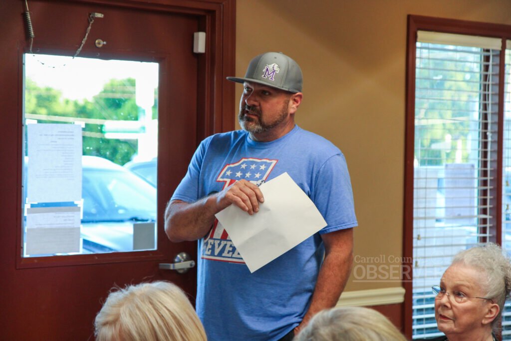 TJ Herndon stands holding a document while speaking to the Atwood board during a town meeting at Atwood City Hall.