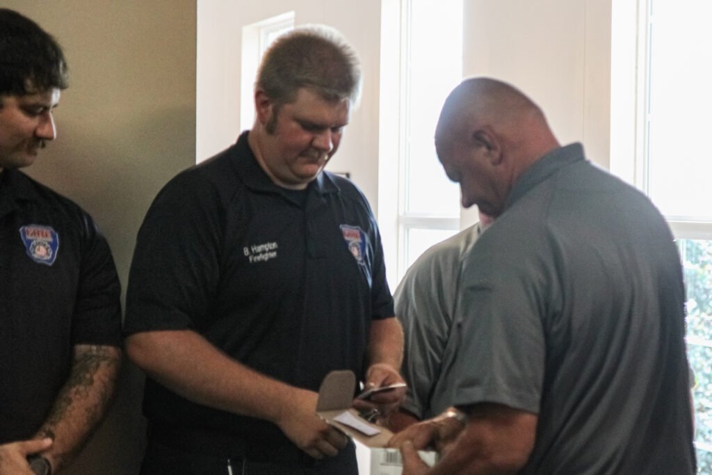 Firefighter Brett Hampton receives his badge from Huntingdon Fire Chief John Fordon after being sworn in.