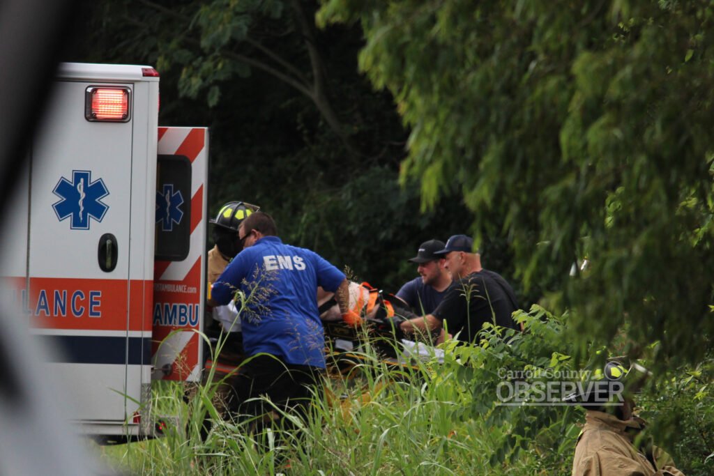 EMS and rescue personnel carry crash victim Eric Cary on a stretcher toward an ambulance in Carroll County, Tennessee.