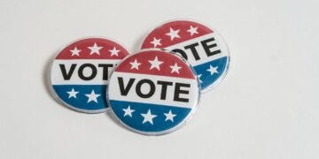 Red, white, and blue voting badges promoting elections on a clean white background.