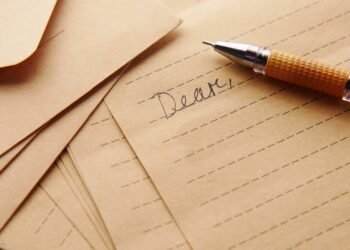 Close-up of vintage lined paper and pen, perfect for letter writing and calligraphy enthusiasts.